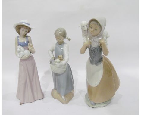 Three Nao figures of young girls, one holding a dog, one holding kittens and one with lamb (3) 