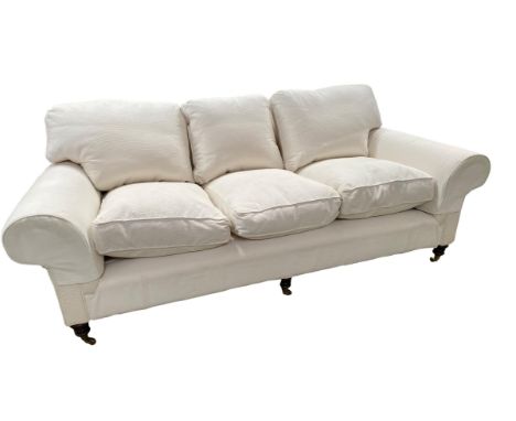 A good GEORGE SMITH three seater cream upholstered sofa, raised on wooden feet to brass castors, 230 cm w x ca 112cm d  CONDI