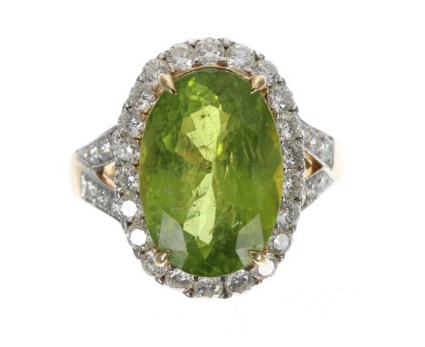 18ct yellow gold oval peridot and diamond cluster ring, the peridot 7.00ct approx, in a border of round-cut diamonds with set