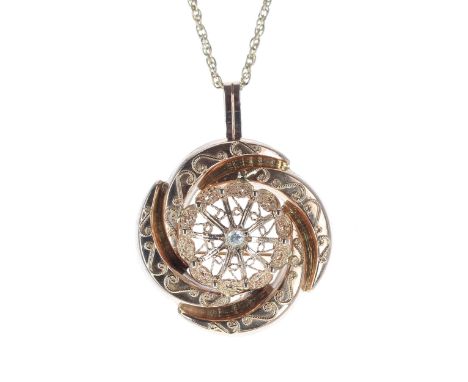14ct circular pendant/brooch with applied scrolls and set to the centre with a brilliant round-cut diamond, 0.10ct approx, 9.