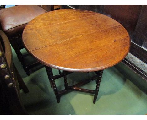 An Edwardian oak 18th Century style Sutherland oval top table the rising leaves over bobbin turned legs joined by stretchers