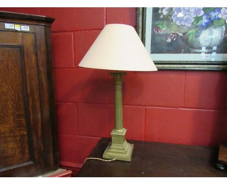 A cast metal column form lamp with stepped base, peach coloured shade