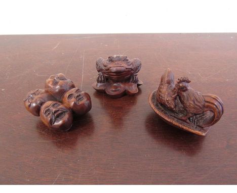 Three signed carved wood netsuke of toad, chickens and faces 