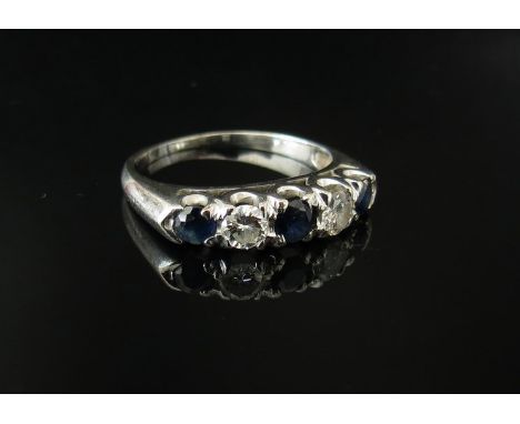 A white gold diamond and sapphire ring the central blue sapphire flanked by a diamond and sapphire in turn, each diamond .20c