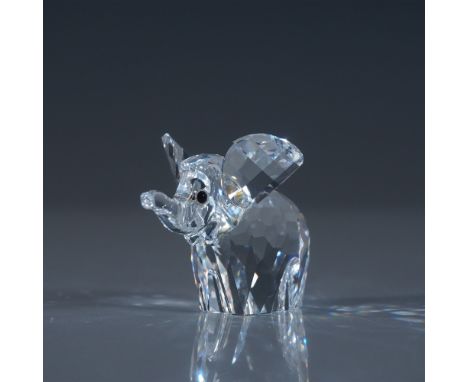 This charming Swarovski Crystal Small Elephant figurine is a beautifully crafted piece showcasing the playful and gentle natu