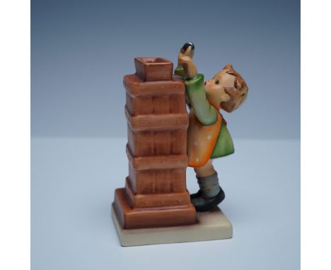 A charming Goebel Hummel "Little Thrifty" figurine depicting a young child placing a coin into a brick-style bank. This hand-