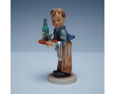 A delightful Goebel Hummel "Waiter Boy" figurine featuring a young boy dressed as a waiter, attentively holding a serving tra