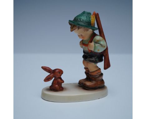 This Goebel Hummel figurine, titled Sensitive Hunter, portrays a young boy in traditional Bavarian attire, gently bowing to a