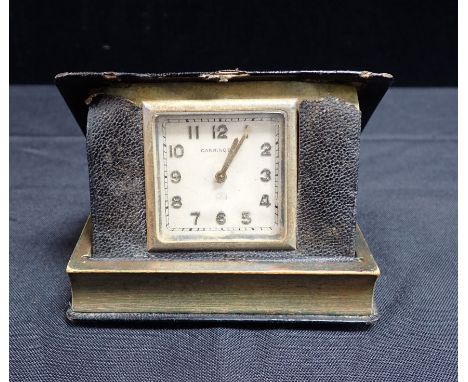 A NOVELTY TRAVEL CLOCK BY CARRINGTON in the form of a book, with gilt inscription 'from Susan and Tony - C.A-J and R. A-J' (A