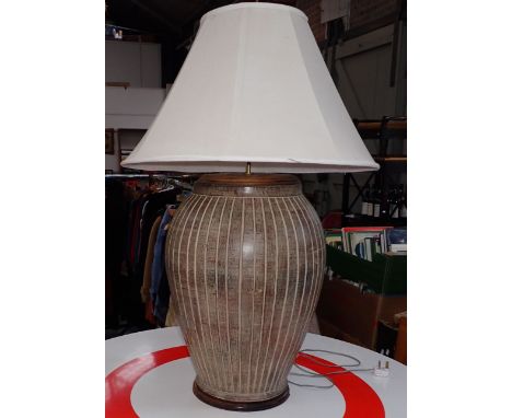 AN IMPRESSIVE POTTERY TABLE LAMP of bellied jar form, with wooden cap and base 60cm high plus fitting and shade