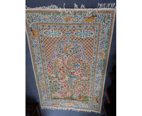 AN INDIAN CREWEL WORK TAPESTRY PANEL woven in colours with exotic flora and fauna, within conforming borders, 182cm x 118cm