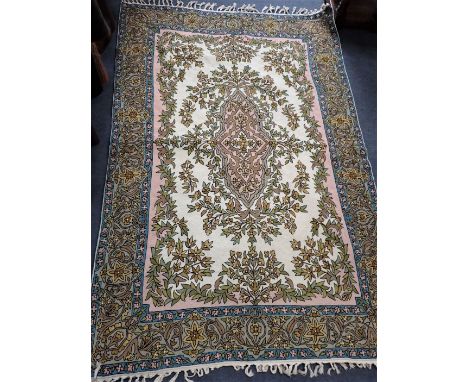 AN INDIAN CREWEL WORK TAPESTRY PANEL woven in muted colours with oval floral and leaf filled medallion and spandrels on a cre