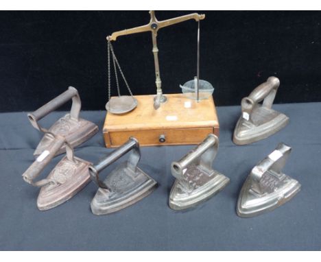 A SET OF DRUGGIST'S SCALES with a collection of laundry flat irons