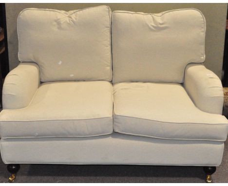 A modern two seat sofa, with caster to the two front feet, 141cm wide x 90cm deep (approx)