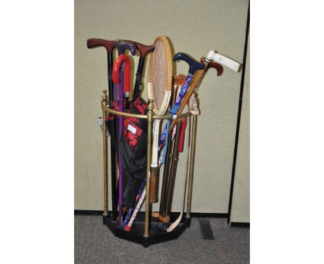 A brass stick stand, 63cm high, containing walking sticks and umbrella