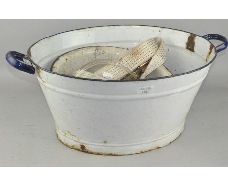 A vintage white enamel wash bowl with blue handles, 63cm wide; together with another enamel bowl