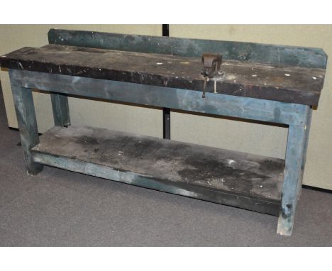 A large wooden work bench, with attached vice, 183cm wide