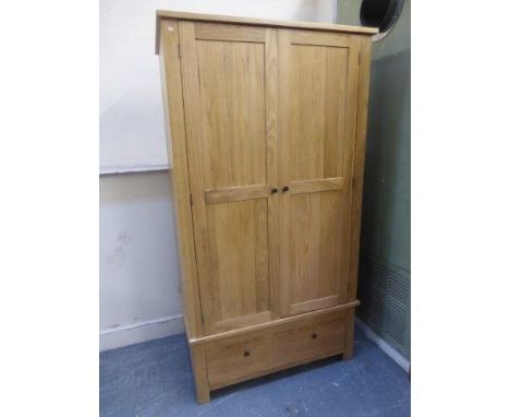 A contemporary light oak wardrobe with single drawer base. 