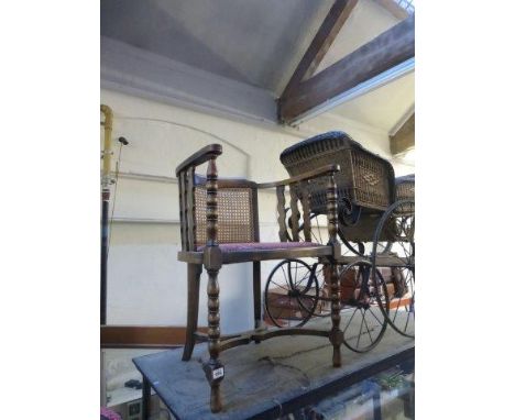 An early 20th Century cane backed bow chair with turned bobbin front supports with curved H stretcher.