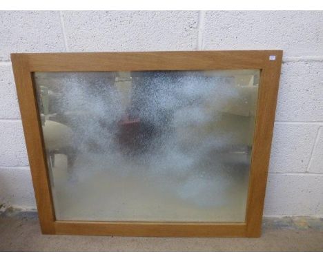 A light oak framed wall mirror