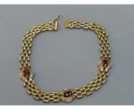 A 9ct gold diamond and ruby gate bracelet.