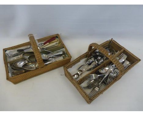 Two cutlery baskets with an assortment of flatware, including four silver teaspoons.