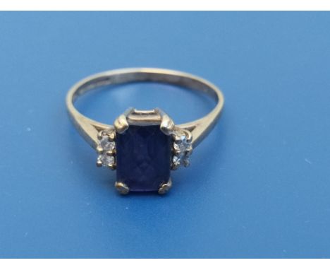 A 9ct gold ring set with rectangular faceted blue paste stone flanked by four small diamonds.  Finger size Q/R.