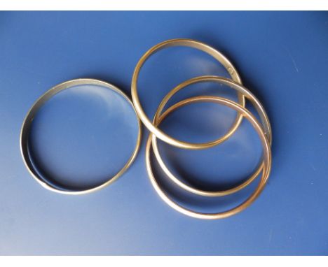 A yellow metal bangle - 'Altinbas 585 193' and a set of three interlinked yellow metal bangles. (4)