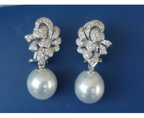 A pair of diamond &amp; cultured pearl set 18ct white gold drop earrings, each comprising a diamond set gold swag above a sin