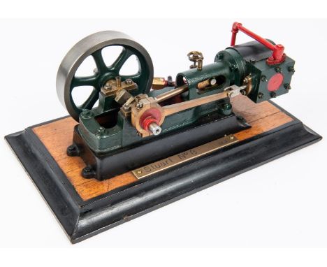 A Stuart live steam stationary engine (No.8). Single cylinder horizontal engine with 90mm flywheel. Mounted on wooden base an