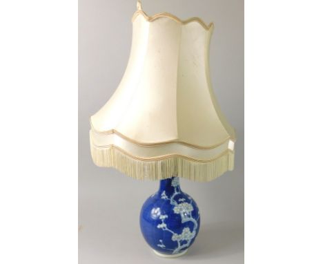 A late 19thC/early 20thC Chinese bottle shaped vase, decorated in blue and white with prunus, converted to a table lamp, the 