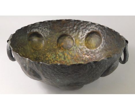 An early 20thC hammered copper Art Nouveau style bowl, with two ring handles, decorated overall with roundels etc., 40cm diam