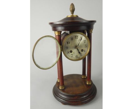 An early 20thC portico mantel clock, the 9cm diameter silvered dial with Arabic numerals, revealing an eight day movement, in