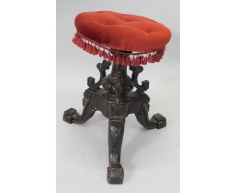 A Victorian mahogany revolving footstool, with a later padded seat, on turned column, and carved tripod base.