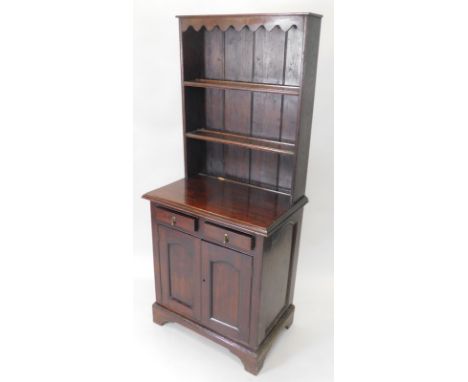 A 20thC oak small dresser, the raised back with two shelves, the base with two drawers and two panelled doors, on bracket fee