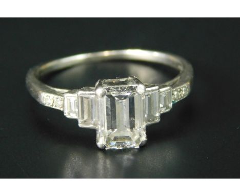 A graduated diamond dress ring, with baguette cut stones and four round brilliant cut stones, on a white metal band, with fai