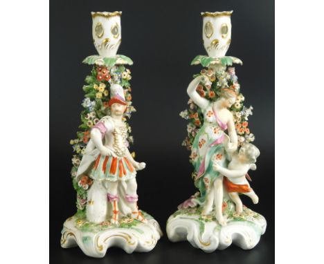 A pair of late 18th/early 19thC Derby porcelain candlestick figures, one modelled in the form of a Greek style soldier, the o