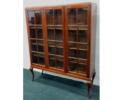 A 20thC mahogany bookcase, with three glazed doors, on cabriole legs, 122cm wide (M)