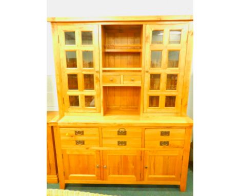 A modern light oak dresser, the top with two glazed doors, flanked by a recess and two short drawers, base with an arrangemen