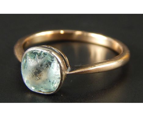 A dress ring, with central rough cut blue stone, in yellow metal, unmarked, 2.7g all in. 