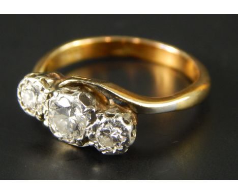 A three stone diamond ring, with three illusion set diamonds, on a twist design white metal head, with yellow metal band, mar