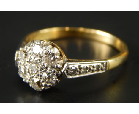 An 18ct gold diamond dress ring, with central floral cluster set with seven diamonds, flanked by three diamonds to each shoul