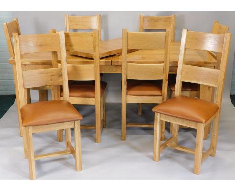 A large modern light oak extending dining table, on square tapering legs, and eight matching ladder back chairs, the table to