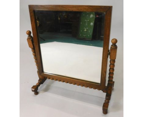 An oak dressing table mirror, on bobbin turned supports, 40cm wide.