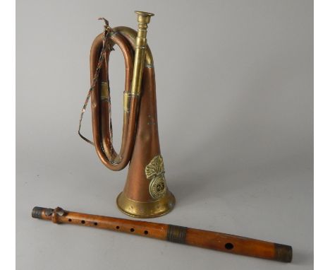 An early 20thC Royal Welsh Fusilier's brass and copper bugle, with raised badge number 23, 30cm wide, and a treen flute with 