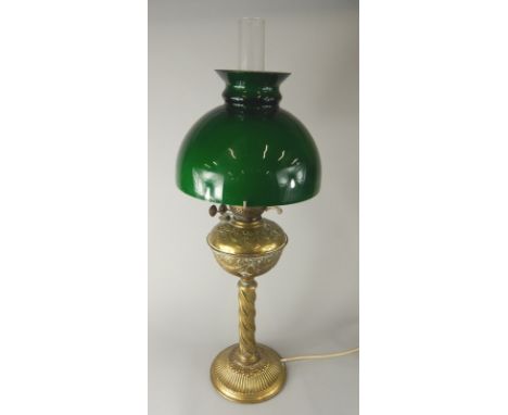 An early 20thC brass column table lamp, with green glass shade, clear funnel and shaped stem, with modern electrical fitting,