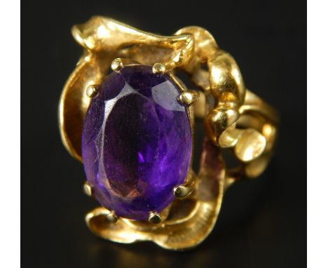 An abstract amethyst dress ring, with central oval cut amethyst, with bark effect style surround, 10.4g all in. 