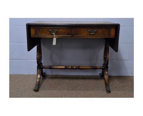 A Regency-style reproduction walnut sofa table, with leather inset double-flap top above a pair of drawers, lyre supports on 