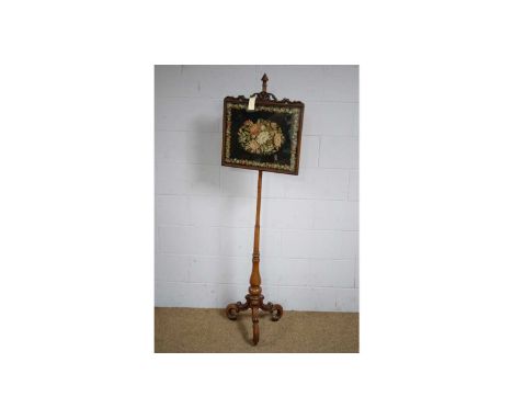 A Victorian turned and carved mahogany pole screen, with shaped rectangular and fretwork panel, 173cms high.