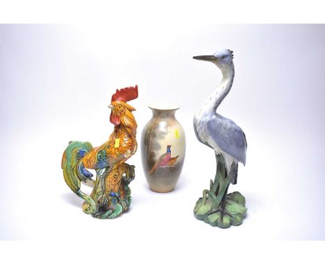 A Spode Copeland’s ceramic figure of a Heron, modelled standing, on a leafy base, 41cms high; together with a Majolica figure